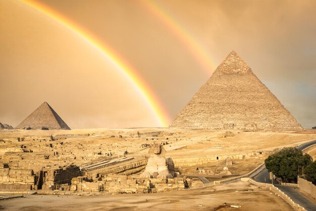 Arco iris sobre Peramids y Sphinx en Giza, Egipto
