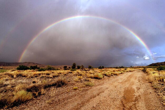 Foto arco iris a través de un camino de tierra cerca del asentamiento de antares en el noroeste de arizona imagen original de la colección de la biblioteca del congreso de américa de carol m highsmith mejorada digitalmente por rawpixel