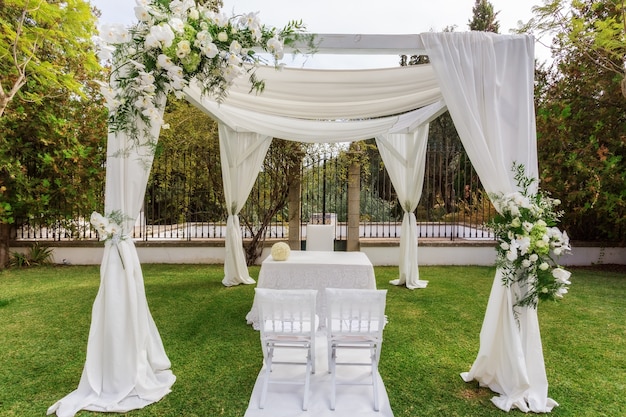 Arco para casamento com uma mesa para os noivos.