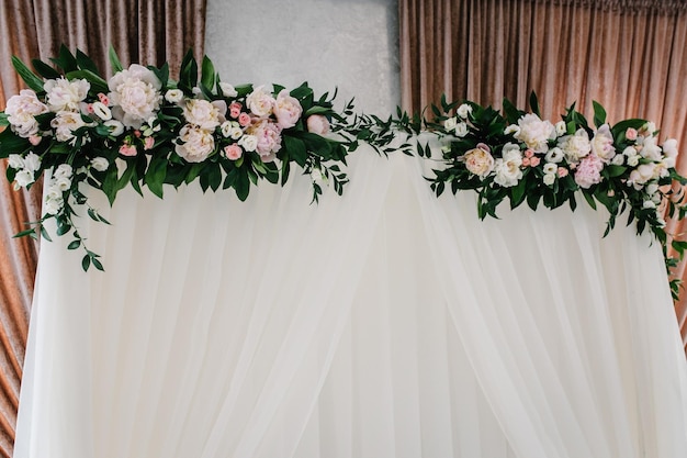 Arco para cerimônia de casamento com composição de flores e vegetação no salão de banquetes de casamento Festa de casamento na tenda