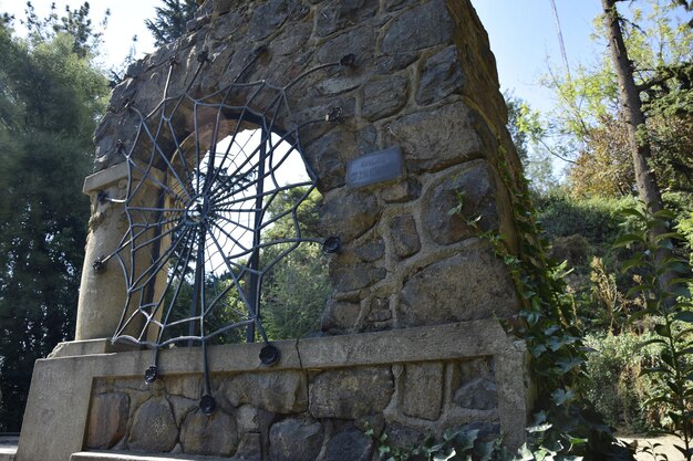 Foto arco de piedra con tela metálica en el parque de la ciudad santiago chile