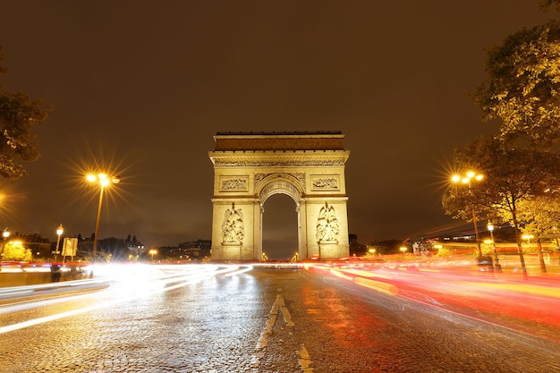 El arco triunfal en la noche lluviosa París Francia