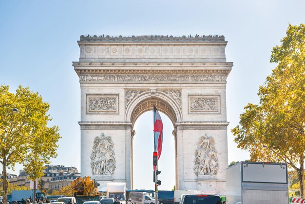 Arco de Triunfo con sol en el cielo azul, en París Francia