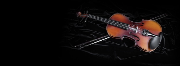 Arco y violín brillante aislado en negro
