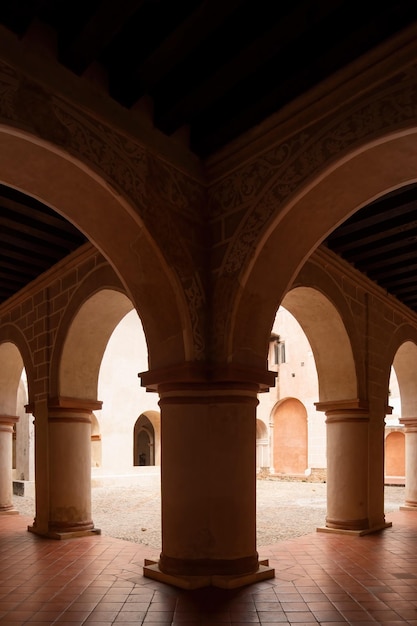 Arcos de arquitetura colonial cercados por vegetação jogo de luzes e sombras dentro do espaço materiais naturais