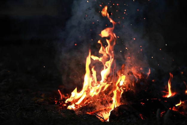 Ardientes chispas al rojo vivo vuelan de un gran incendio. Carbones ardientes, partículas llameantes que vuelan sobre fondo negro.