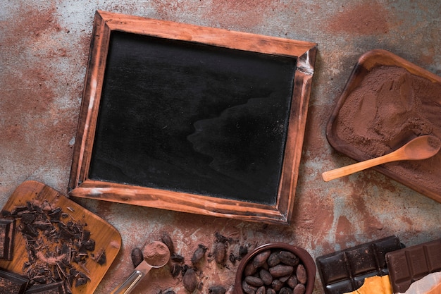 Ardósia em branco de madeira com barra de chocolate, cacau e pó na mesa rústica