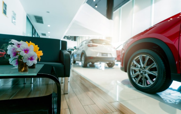 Foto Área de recepção ao cliente e desfoque de carro suv luxuoso vermelho e branco estacionado em um showroom moderno