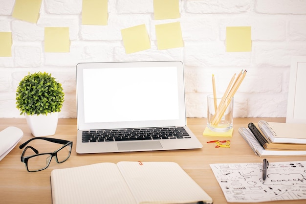 Área de trabalho criativa com laptop branco