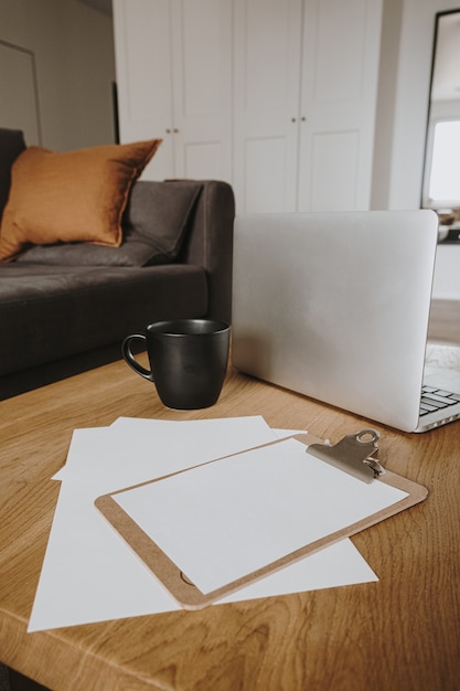 Área de trabalho da mesa do escritório doméstico com bloco de notas em branco da prancheta