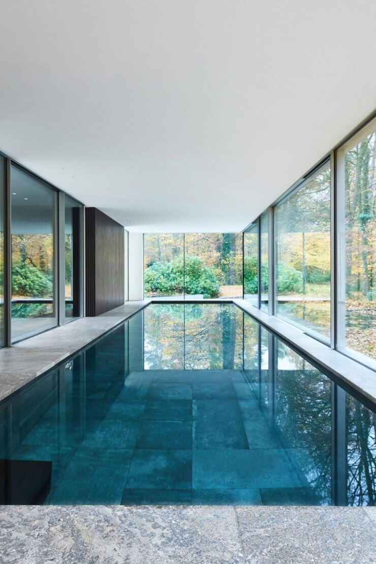 el área de la piscina está revestida con paneles de vidrio y las ventanas están hechas de vidrio
