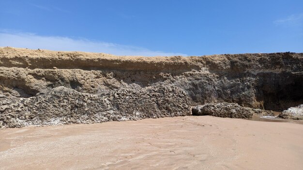 Areia balança rochas e céu na praia em Lisboa