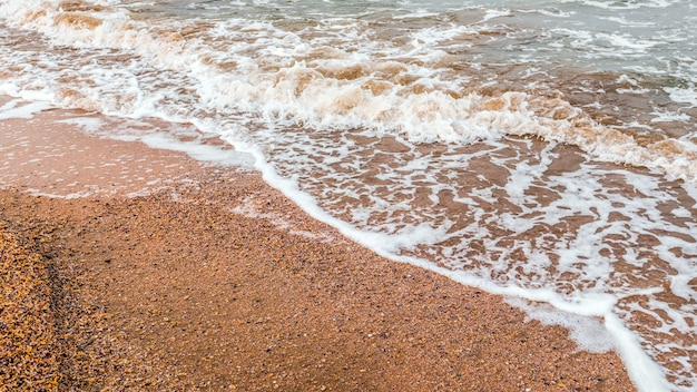 Areia dourada e fundo de ondas do mar