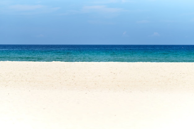 Foto arena blanca, mar azul profundo y el cielo en un día soleado con espacio de copia