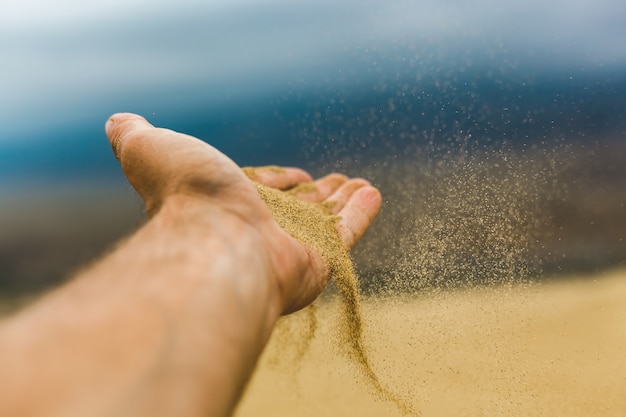 La arena cae de la palma de tu mano en el viento