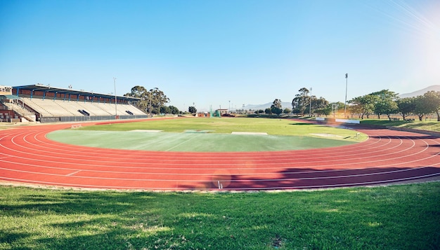 Arena de pista de corrida vazia ou arquitetura de estádio para treinamento cardio de esportes de corrida de maratona ou treino de fitness Curso olímpico de céu azul e campo de eventos para competição de atletismo ou jogos