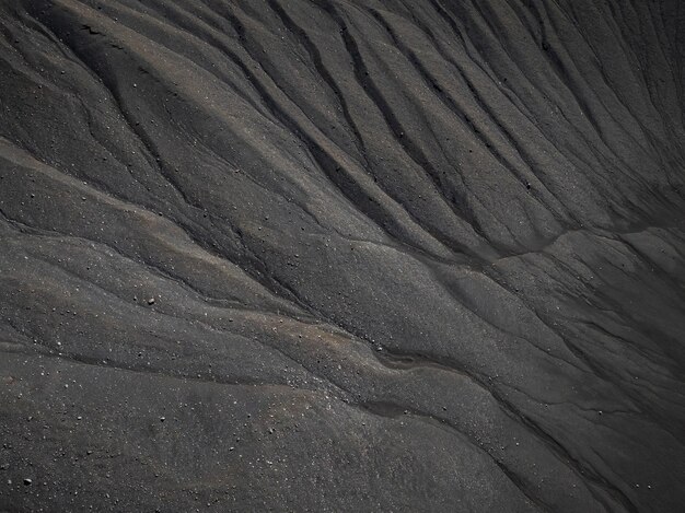 Arena oscura arenas volcánicas negras texturas de las olas tomadas desde el aire
