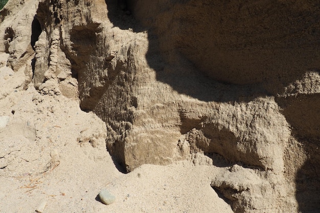 Arenito é uma rocha sedimentar fragmentária um agregado homogêneo ou em camadas de grãos fragmentados e grãos de areia ligados por qualquer substância mineral cimento Pedreira parede de areia amarela natural