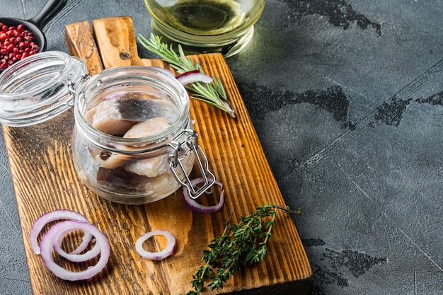 Arenque en escabeche en aceite sobre fondo gris con espacio para copiar texto