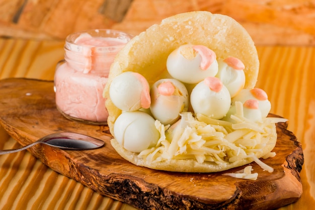 Arepa incomum com ovos de codorna e molho especial de rosa