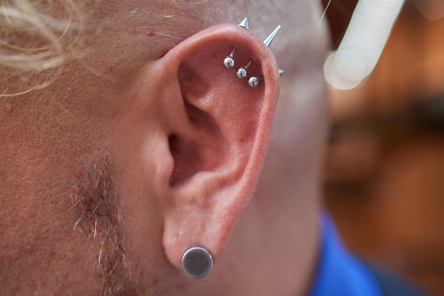 Aretes y piercing en la oreja de los hombres moda femenina juvenil