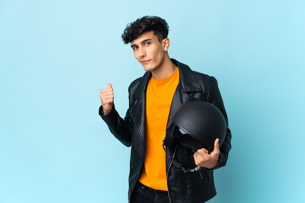 Argentinischer Mann mit einem Motorradhelm, der zurück zeigt