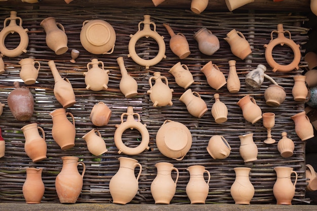 Foto argila marrom, vários potes e jarros de cerâmica, em uma loja de cerâmica artesanal