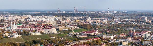 Ariel Panoramablick auf die Altstadt und moderne Wolkenkratzer mit einer riesigen Fabrik mit rauchenden Schornsteinen im Hintergrund