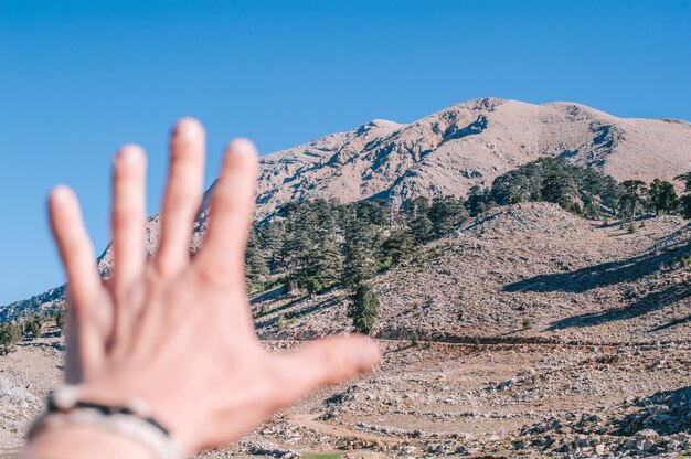 Arm, der die schönen Berge ausdehnt