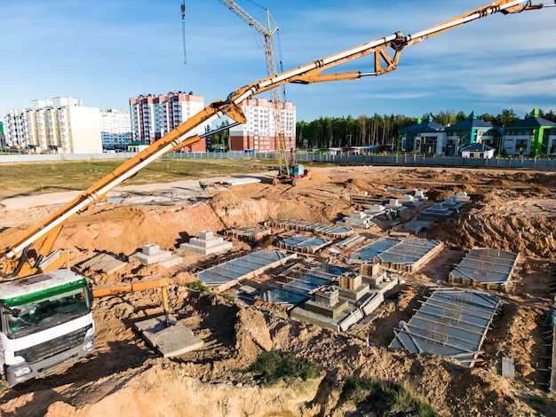 Arm einer Betonpumpe bereit für die Betonförderung auf der Baustelle. Ausleger eines Betonpumpenwagens vor dem Himmel im Hintergrund. Ansicht der LKW-Betonpumpe von oben