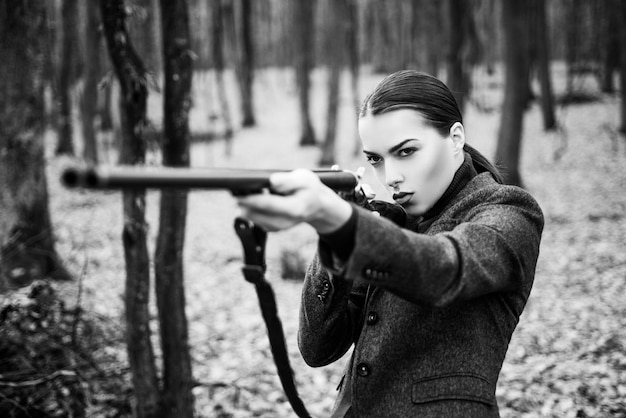 Arma de caza pistola o rifle moda militar logros de metas chica con rifle persecución caza Tienda de armas mujer con arma Tiro al blanco cazadora en el bosque caza exitosa deporte de caza