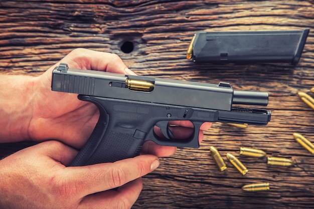 Arma de carga. mãos de homem carregando uma pistola de 9 mm.