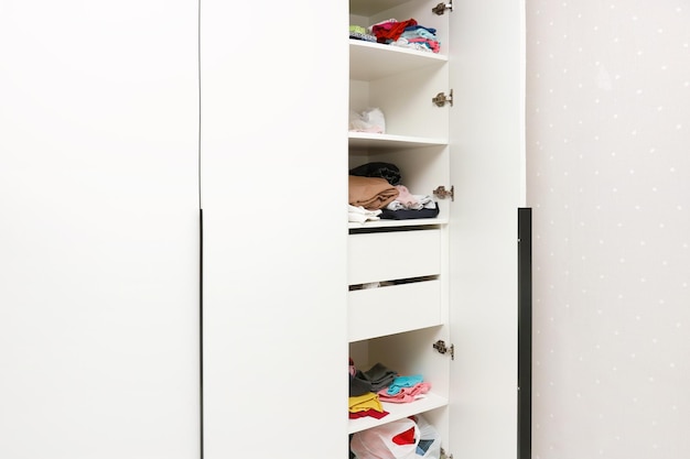 Foto armario con puerta abierta lleno de ropa