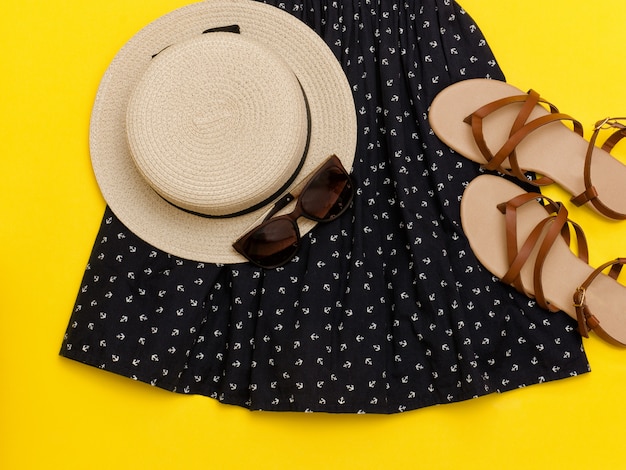 Armario de verano femenino Sombrero de paja, vestido de verano, gafas de sol, sandalias Fondo amarillo