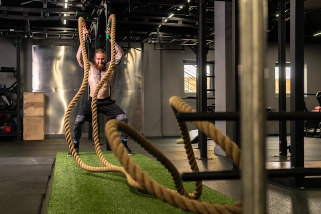 Armazém de corda fitness homem verde treino de grama ginásio muscular jovem para forte força física de atividade saudável músculo pessoa Cross ground holding