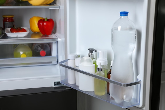 Armazenamento de cosméticos e água na lixeira da porta da geladeira ao lado de mantimentos