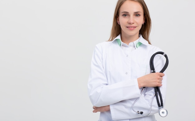 Armcrossed Portrait des weiblichen lächelnden Doktors auf Grau