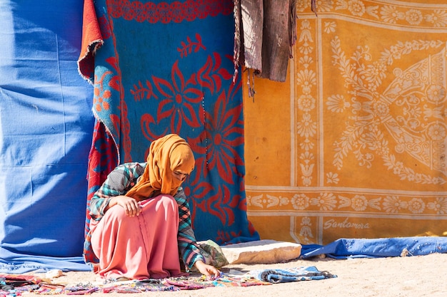 Arme Beduinenfrau, die ihre handgefertigten Accessoires verkauft und die traditionelle Kleidung trägt. Sinai, Ägypten