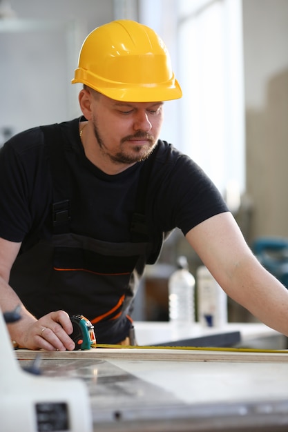 Arme des Arbeiters, der Holzstangen-Nahaufnahme misst