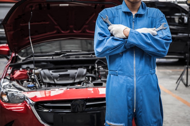 Arme verschränkt von Automechaniker, der Autoservice und -wartung tut.