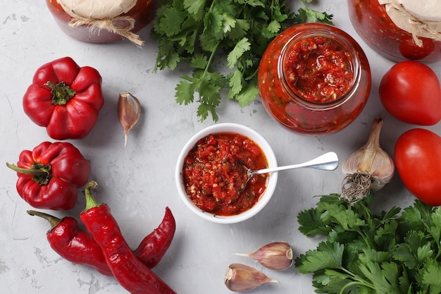 Armenische Adjika von Paprika Tomaten Knoblauch Koriander und Petersilie in einer Schüssel und Gläser