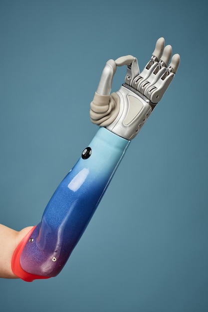 Armprothese mit OK-Zeichen isoliert auf blauem Innovations- und Wissenschaftsentwicklungskonzept