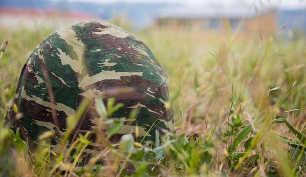 Army Camouflage Helm auf den Boden gelegt Nahaufnahme Vorderansicht verschwommener Naturhintergrund Copyspace