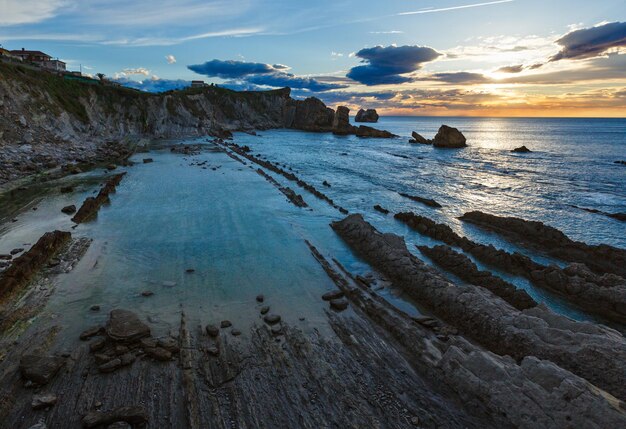 Arnia Beach (Spanien) Atlantikküsten-Sonnenuntergangansicht von felsigen Steinen.