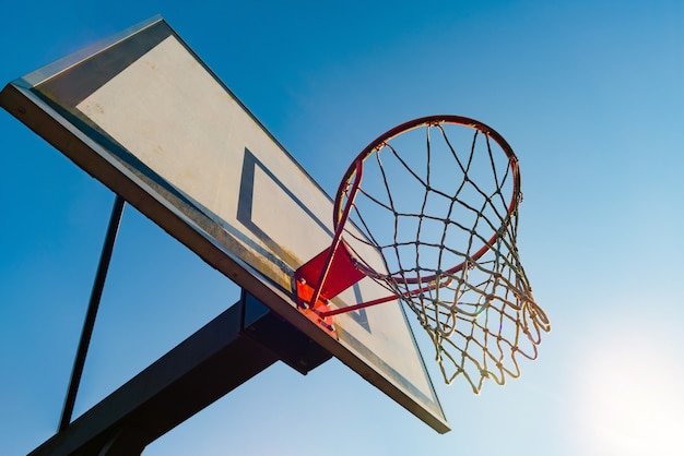Foto aro de baloncesto de la calle en un día soleado con el cielo azul de fondo. juego de juventud urbana. concepto de éxito, sumar puntos y ganar