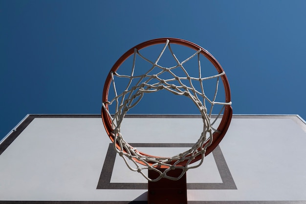 Aro de baloncesto en la cancha de baloncesto al aire libre con vista de ángulo bajo de fondo de cielo azul