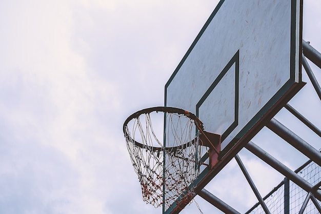 Aro de baloncesto en un día azul y cielo nublado, filtro de color añadido