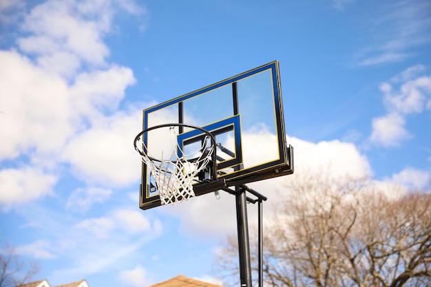 Un aro de baloncesto está colocado contra un cielo azul.