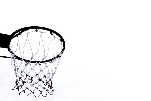 Aro de baloncesto visto desde abajo sobre fondo blanco Una vista de un aro de baloncesto desde abajo