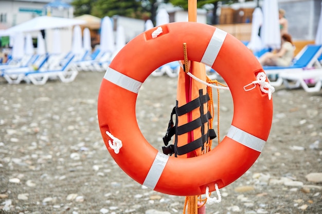 Aro salvavidas en una playa de guijarros con el telón de fondo de las tumbonas